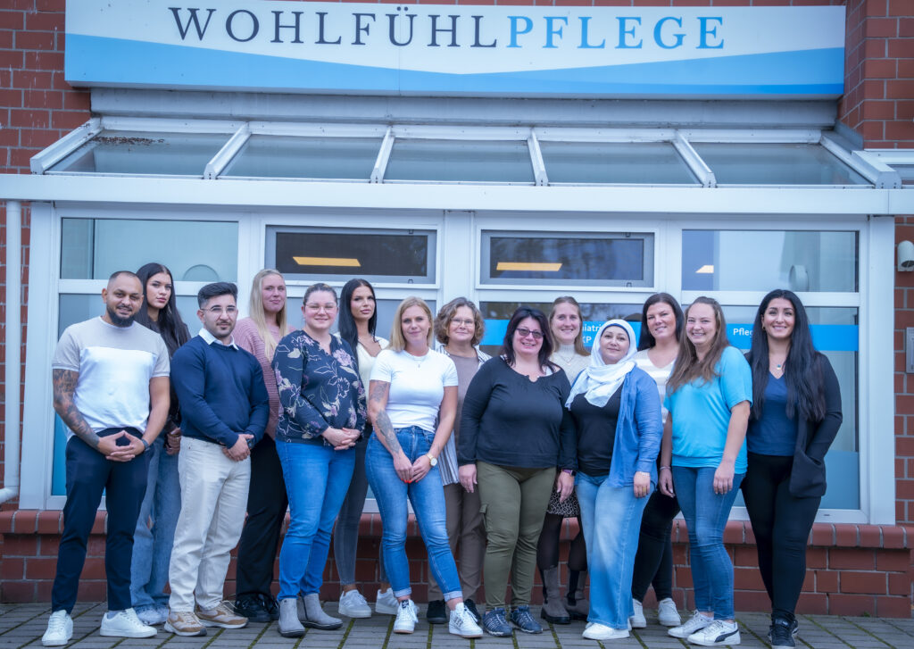 Gruppenfoto vor einem Pflegeeinrichtungsschild.